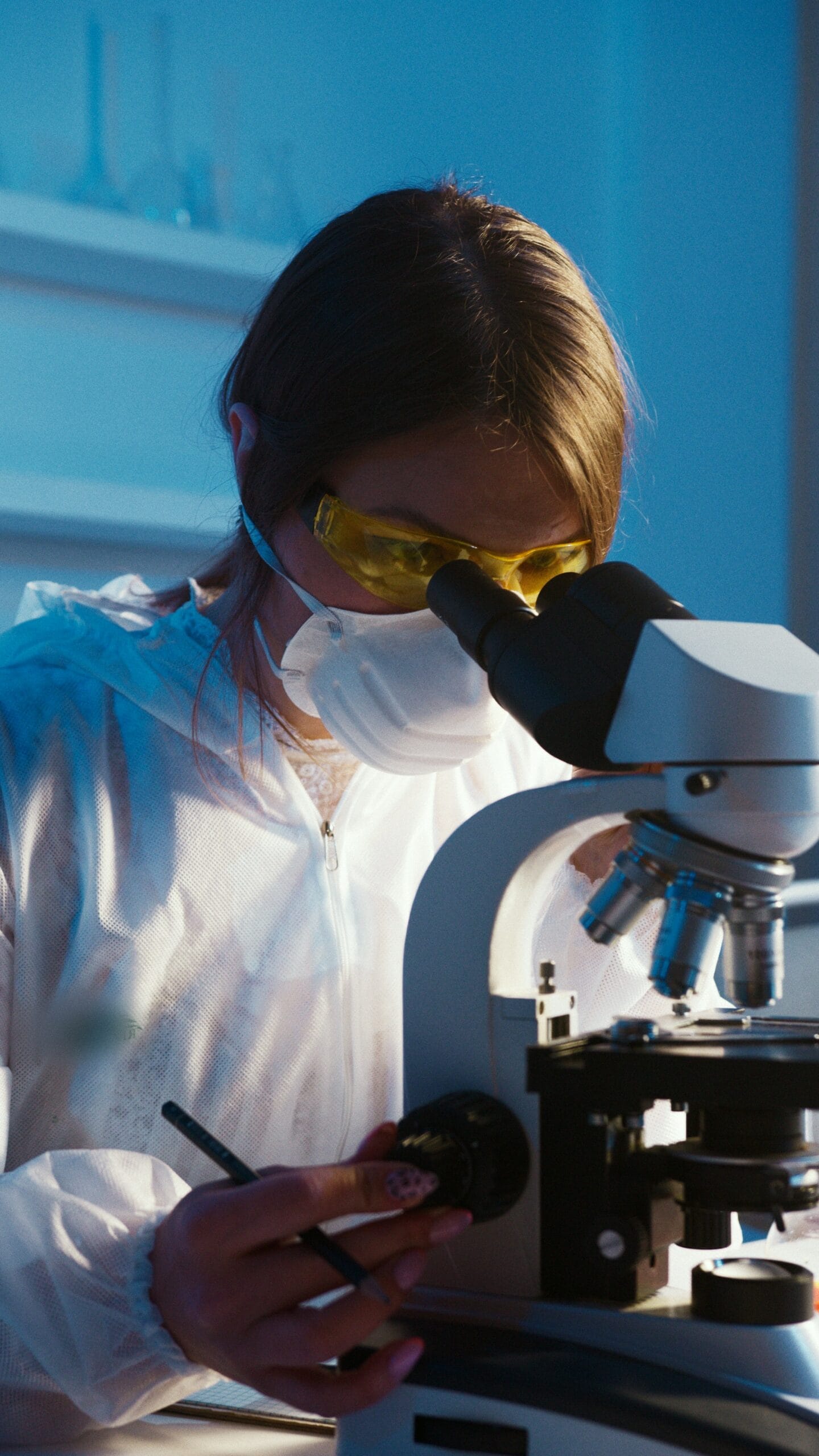 lab technician looking through microscope front view