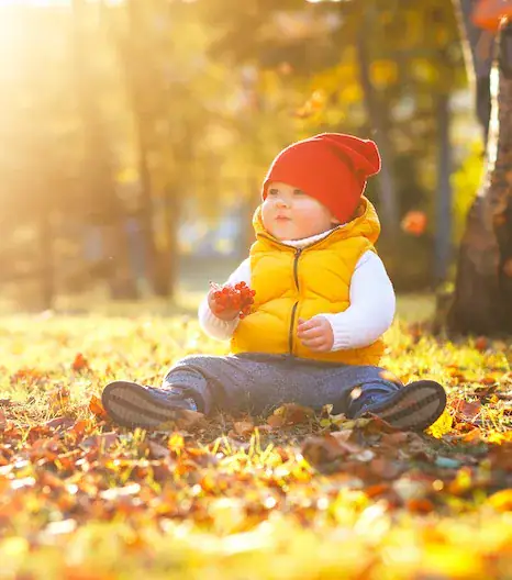 baby playing in leaves