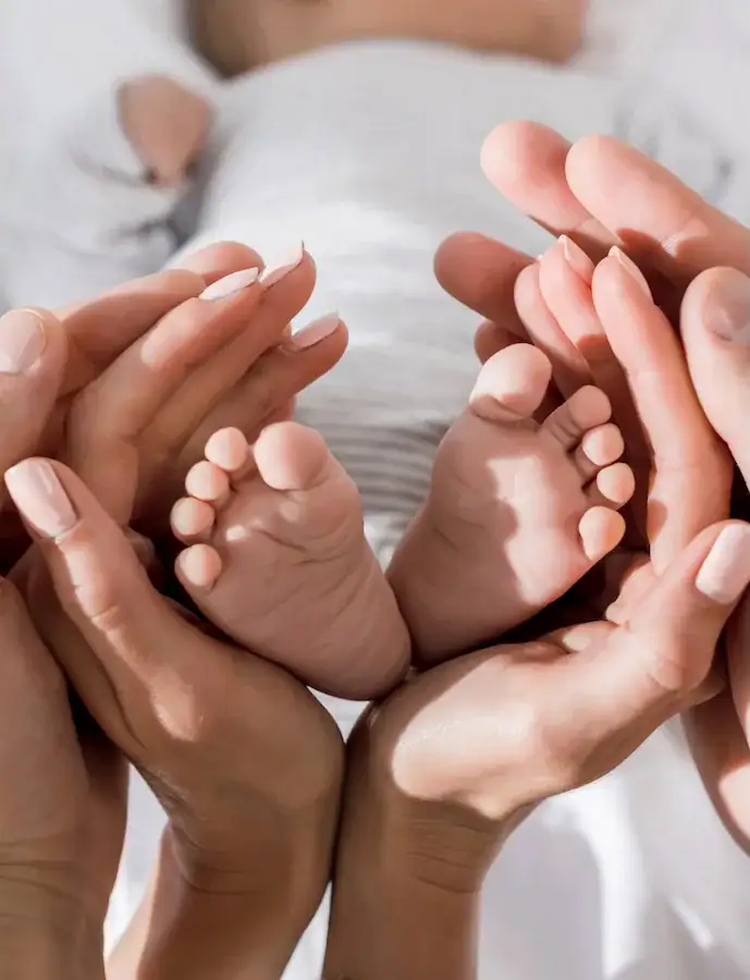mom and dads hands holding newborn baby's feet