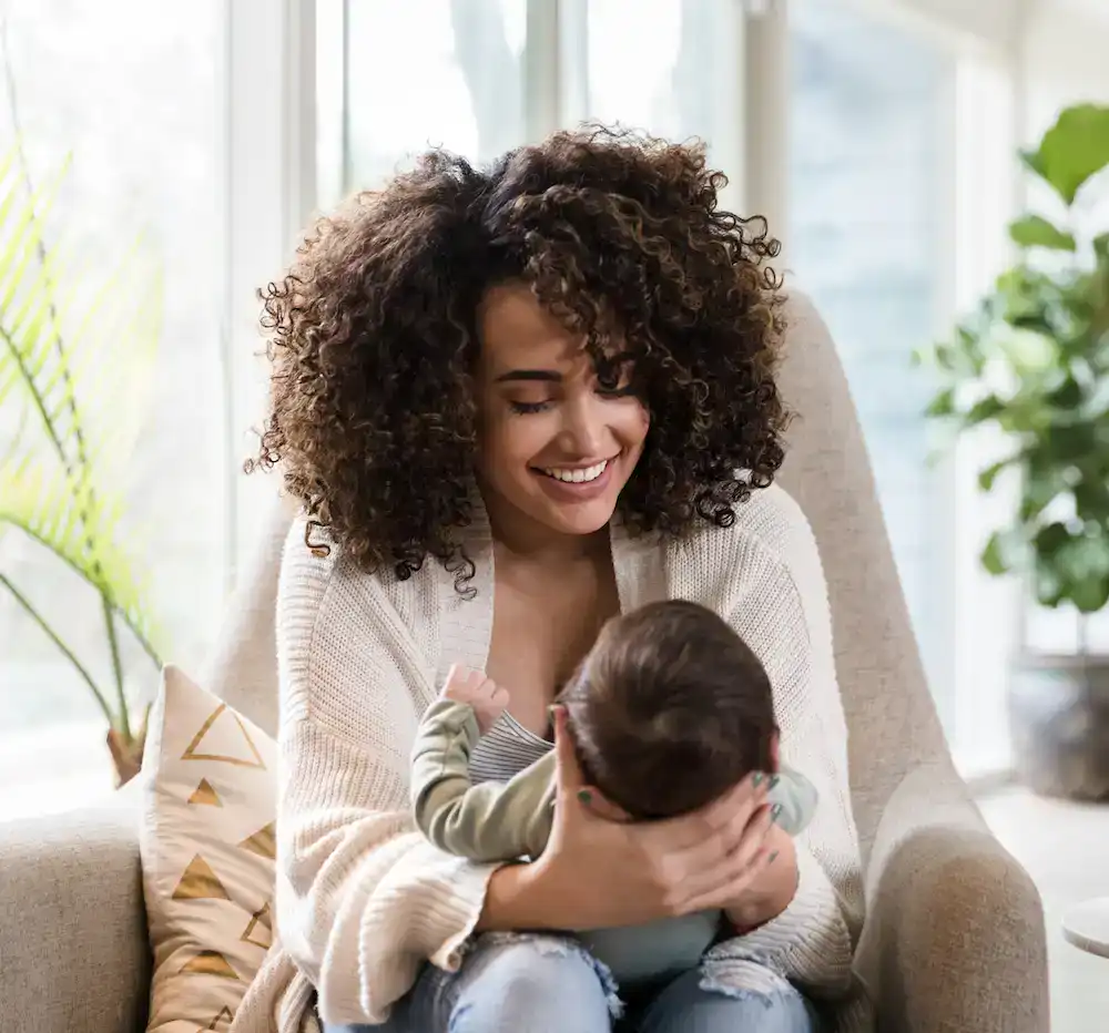 mom holding baby and smiling