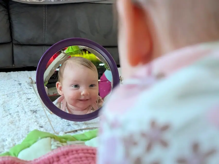 baby exton looking in mirror